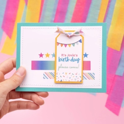 Cartão de aniversário multicolorido com etiqueta e fundo festivo