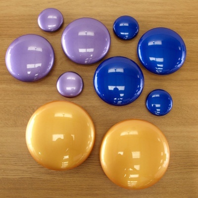 Conjunto de botões coloridos redondos em três cores brilhantes sobre madeira