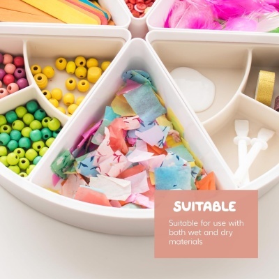 Tabuleiro branco com compartimentos contendo materiais para artesanato coloridos e uma etiqueta com texto em inglês.