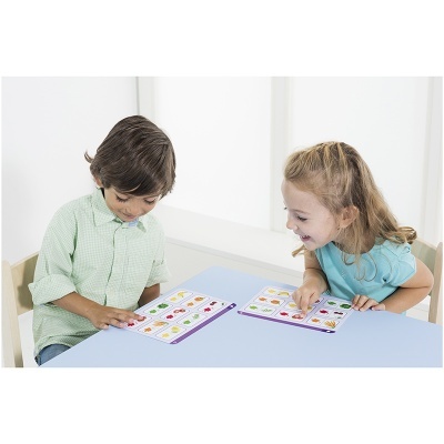 Duas crianças jogando com cartões coloridos numa mesa azul