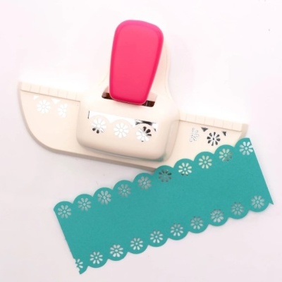 Cortador de papel de borda floral branco e rosa com amostra azul recortada