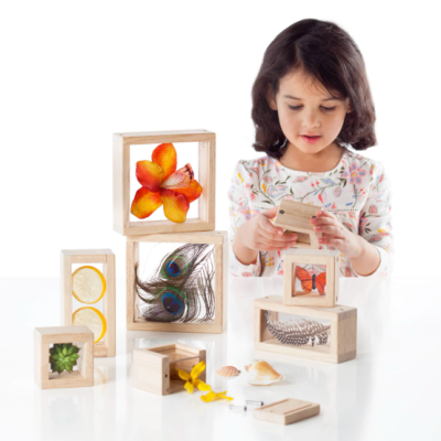 Blocos educativos em madeira com elementos naturais e criança a brincar