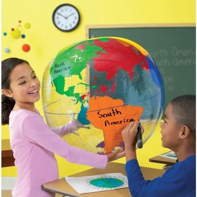 Crianças a utilizar globo terrestre insuflável numa sala de aula