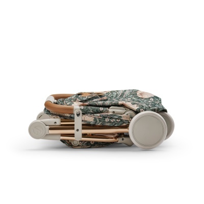 Carrinho de bebé dobrado com tecido floral verde e bege