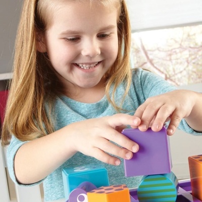 Menina a brincar com blocos de construção coloridos