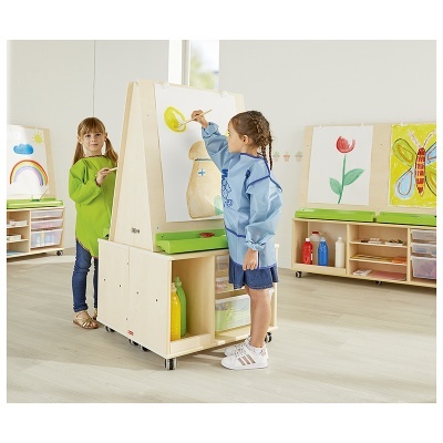 Crianças a pintar num cavalete de madeira com tintas