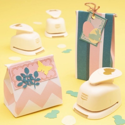 Perforadores de papel decorativos e embrulhos coloridos em superfície amarela