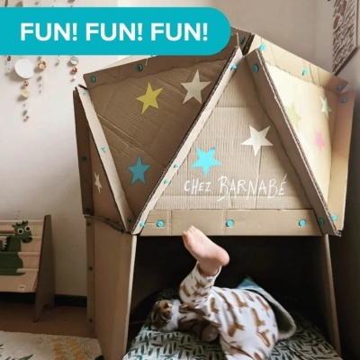 Tenda infantil de cartão com estrelas coloridas e texto 'CHEZ BARNABÉ', criança de pijama dentro