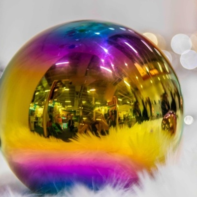 Esfera decorativa refletora com cores metálicas sobre base branca fofa