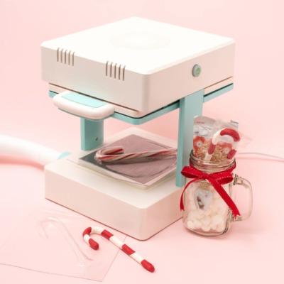 Máquina moldadora de doces branca e azul com varinha doce e frasco de vidro com marshmallows