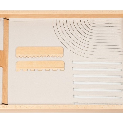 Tabuleiro de madeira com objetos organizados sobre tecido bege