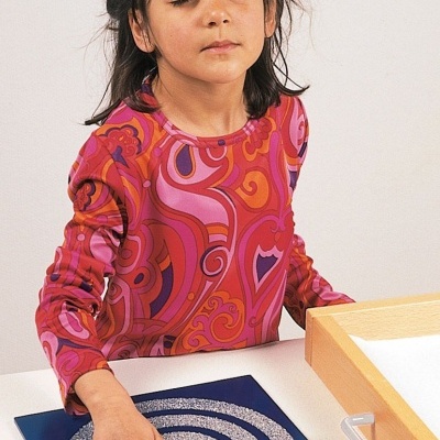 Camisola com padrão psicadélico colorido em criança a tocar numa prancha azul com espiral.