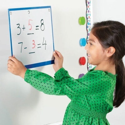 Menina vestida de verde segura quadro branco com operações matemáticas