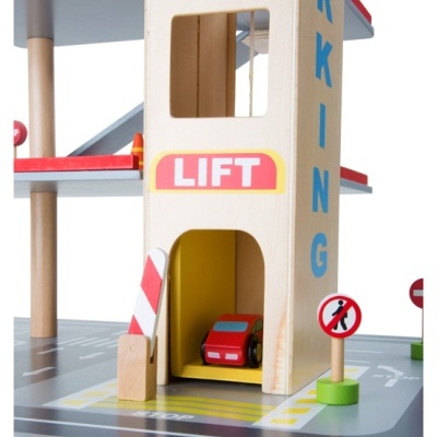 Torre de estacionamento de brinquedo em madeira com carro vermelho e sinais de trânsito.