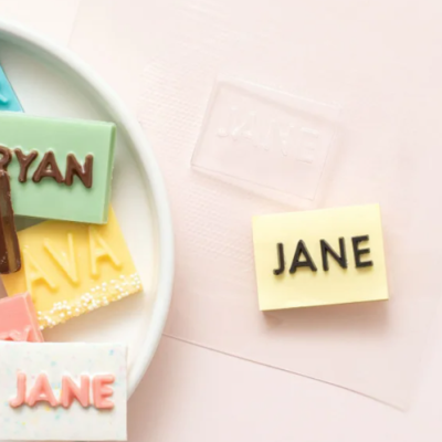 Blocos rectangulares de chocolate coloridos com nomes em letras maiúsculas