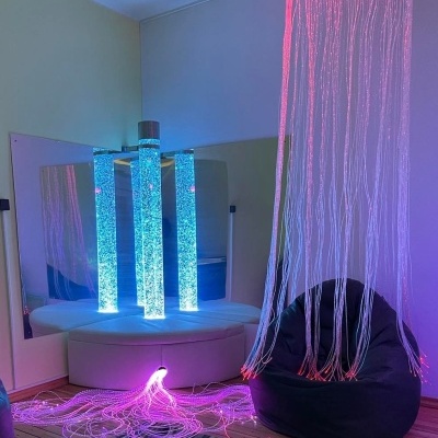 Sala com colunas iluminadas e fios luminosos cor-de-rosa