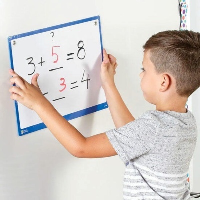 Criança segurando placa branca com operações matemáticas escritas