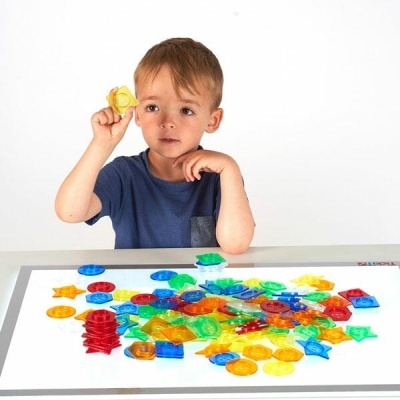 Criança a brincar com peças coloridas transparentes