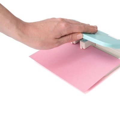 Furador de papel azul claro a perfurar papel rosa