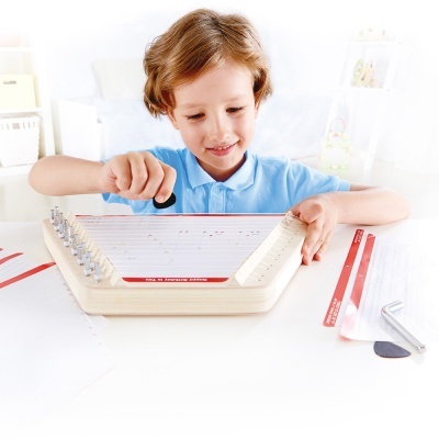 Criança a tocar instrumento musical de cordas em mesa branca