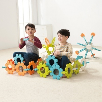 Crianças brincando com peças plásticas coloridas de encaixe no chão