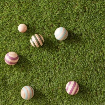 Sete bolas de madeira coloridas sobre relva artificial