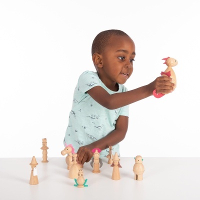 Criança a brincar com peças de madeira coloridas com detalhes cor-de-rosa