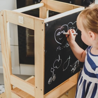 Móvel educativo em madeira com quadro negro e espelho, menina a desenhar
