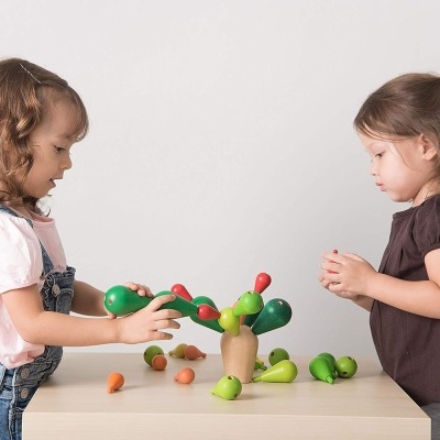 Crianças a brincar com brinquedo de madeira em forma de árvore sobre mesa