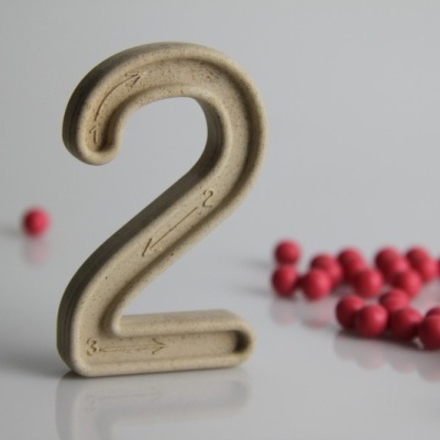 Número 2 castanho claro com setas em fundo branco e bolas vermelhas