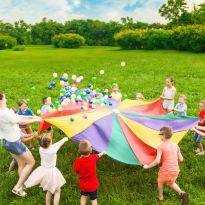 Crianças a brincar com pano colorido ao ar livre