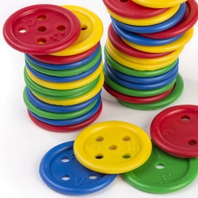 Botões plásticos grandes coloridos empilhados e espalhados sobre fundo branco