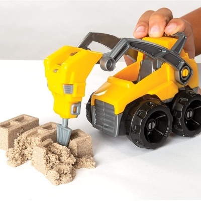 Carrinho de construção amarelo e preto com broca a escavar areia