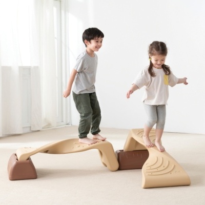 Crianças a brincar em brinquedos de equilíbrio em plástico bege e castanho
