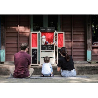 Teatro de marionetas com família a assistir sentado no chão