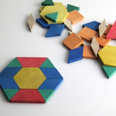 Peças geométricas de madeira coloridas sobre mesa branca