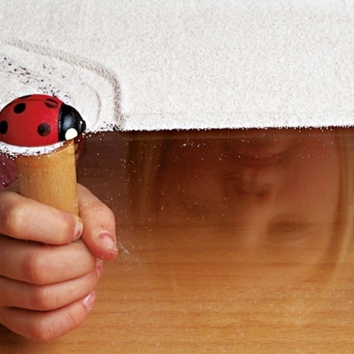 Mão infantil com cone de gelado e joaninha de brinquedo no topo