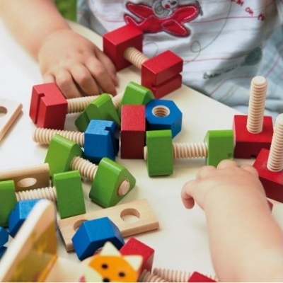 Blocos de madeira coloridos e mãos de crianças brincando