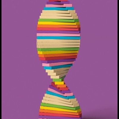 Escultura colorida feita de blocos de madeira empilhados em camadas horizontais em fundo roxo