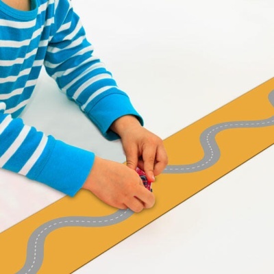 Criança a brincar com carro num tapete com estrada desenhada