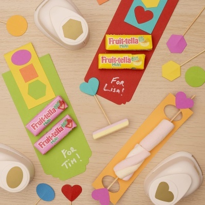 Marcadores de livro coloridos com doces Fruit-tella Mini e marshmallows, formas de papel recortadas e furadores de papel.
