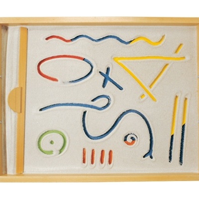 Tabuleiro de madeira com areia branca e varetas coloridas organizadas abstratamente