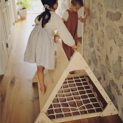 Estrutura triangular de madeira para escalada infantil com rede de corda e crianças a brincar