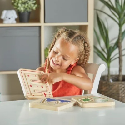 Criança a brincar com brinquedo educativo de madeira num ambiente interior