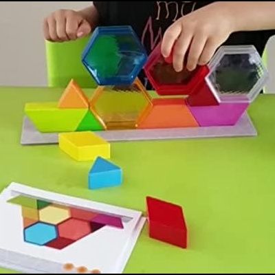 Conjunto de blocos de empilhar coloridos em plástico translúcido numa base com cartão de instruções.