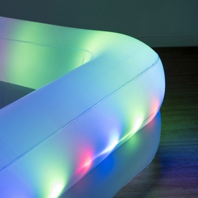 Piscina insuflável branca com luzes LED coloridas integrada, em chão de madeira escura