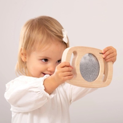 Criança a segurar tábua de madeira com superfície cinzenta oval