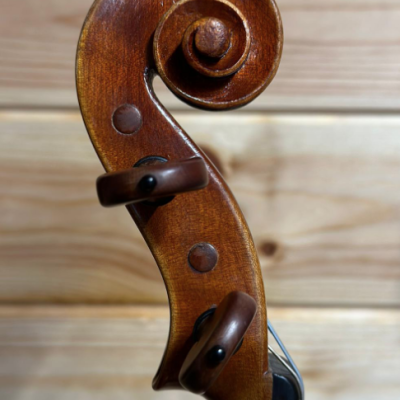 Cabeça de violino em madeira castanha com cravelhas escuras
