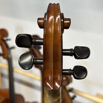 Cabeça de violino em madeira castanha com cravelhas pretas