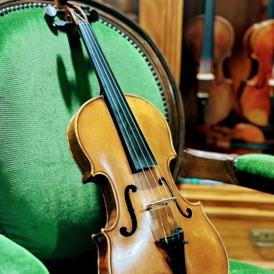 Violino de madeira sobre cadeira verde